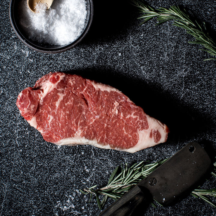 Two thick-cut Blackwater NY Strip steaks on butcher paper.